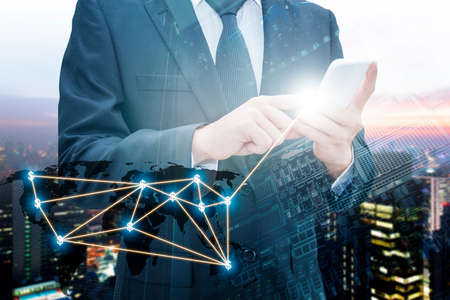 Double exposure of professional businessman using smart phone with servers technology in data center...