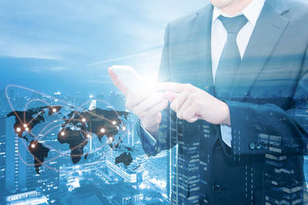 Double exposure of businessman touching with smart phone world business network connection and city center of business, Technology communication business and finance concept, world map from NASAの写真素材