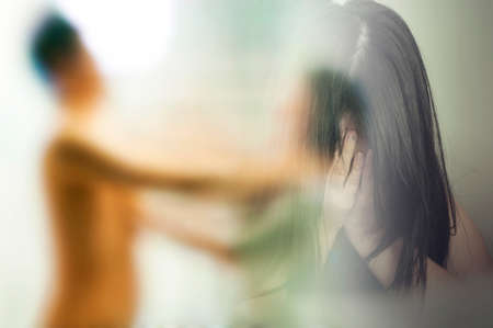 Double exposure of Woman covering her face in fear and blurred young woman abused domestic violenceの写真素材