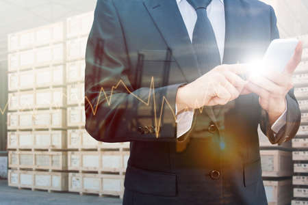 Double exposure of professional businessman using smart phone and city centre of business with...