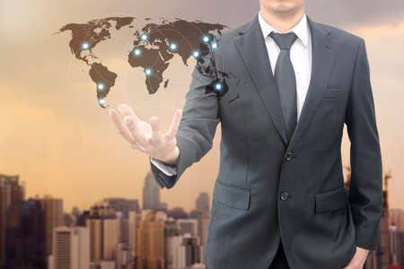 Businessman hold world map connect international network with cityscape of business background for trading and business concept,の写真素材