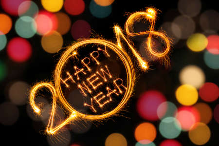 Happy New Year 2018 written with Sparkle firework and defocused colorful lights bokeh background