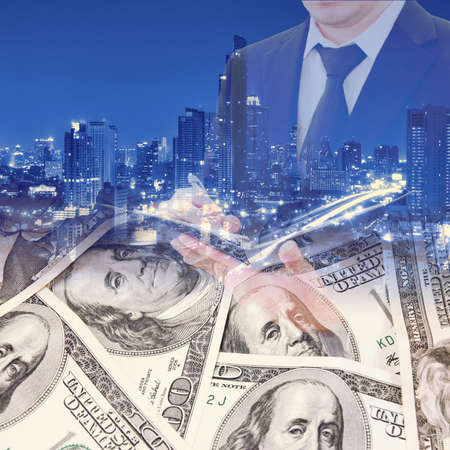 Double exposure of businessman, night city and group of international coins for busines finance conceptの写真素材