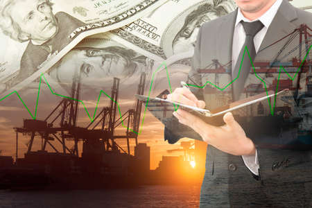 Businessman writing notebook with blurred cargo in wooden case and transportation port background, trading export abroad conceptの写真素材