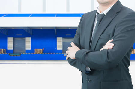 Professional business man with blurred distribution warehouse dock background, industrial business conceptの写真素材