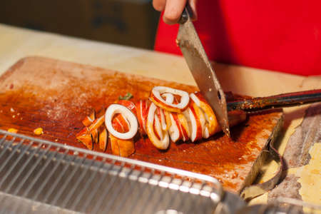 Cutting squid grilled on cutting board at street food night market in Taiwanの写真素材