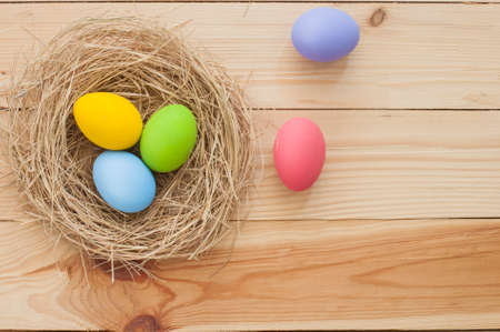 Easter eggs in nest on wood backgroundの写真素材