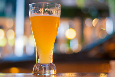 Glass of light beer with blurred light background in a pubの写真素材