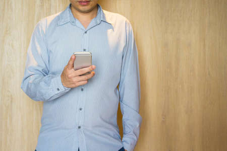 Casual smilling man touching smartphone with copy space in business , finance , communication and...
