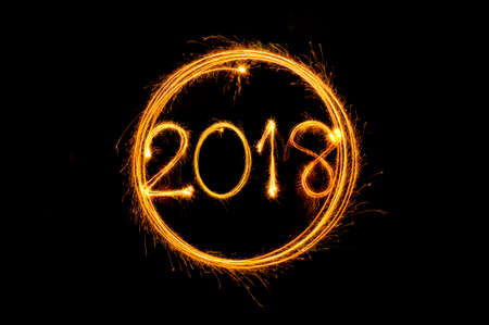 Happy new year 2018 text written with Sparkle fireworks isolated on black backgroundの写真素材