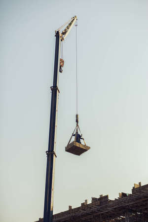 Workers work in a basket on the crane の写真素材