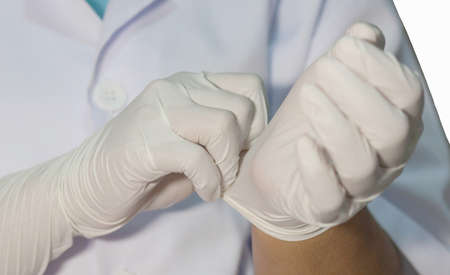 The doctor wears gloves to protect against viruses And patientsの写真素材