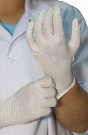 The doctor wears gloves to protect against viruses And patientsの写真素材
