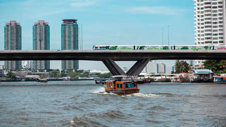 Boats on the river and the train tracks and buildings in the city center of Thailand のeditorial素材