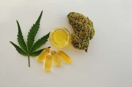 Marijuana buds, oil pills, cbd recreation. Fresh cannabis leaf close up, isolated on white background. Home relaxation, pastime therapy. Alternative medicine.の写真素材