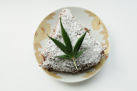 Chocolate cake with cannabis and coconut flakes isolated on white background.の写真素材