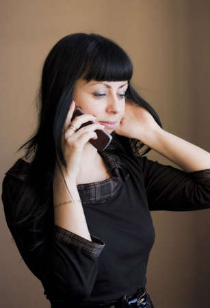 woman with dark hairs listening by cell phoneの写真素材