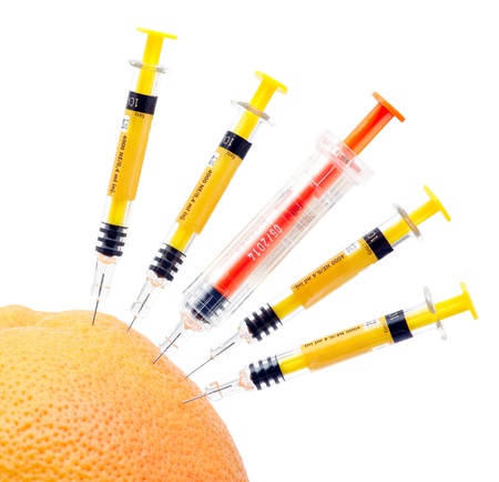 Syringes and orange on white background.の写真素材