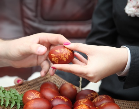 Woman give an decorated easter egg.