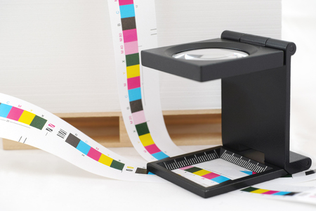 Prepress color menagement in print production. CMYK color check on printed paper. Quality printing concept.の写真素材