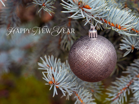 Golden toys on Xmas tree against blurred lights.の写真素材