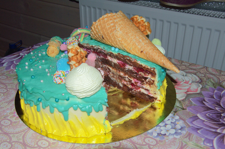 beautiful birthday cake in icing with fillings of fruit, marshmallows, waffles, and fruitの写真素材