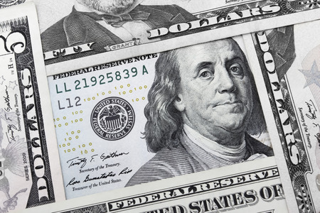 4 US Dollar (USD) notes are forming a square with a 100 USD note in the middle.