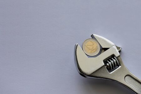 Wrench and money on blue background. Economy tool.の写真素材