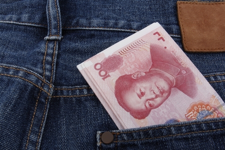 Chinese money (RMB) 100 RMB note in a pocket of a pair of blue jeansの写真素材