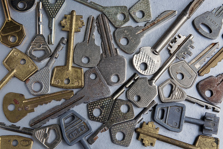 Keys of different shapes and colors on a gray backgroundの写真素材