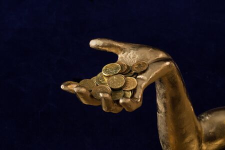 a handful of coins in gold-plated handの写真素材