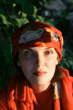 woman in a red dress and scarf  in the gardenの写真素材