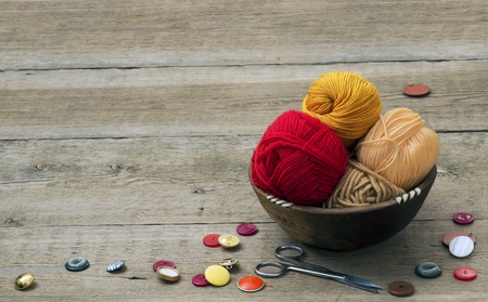 buttons, scissors and yarn on a wooden tableの写真素材