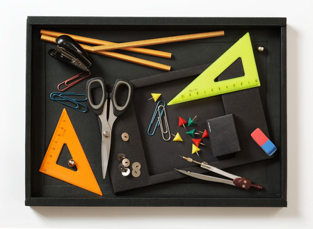 colorful office supplies in a black box on a white backgroundの写真素材