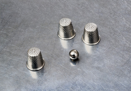 thimbles and a ball on a silver backgroundの写真素材