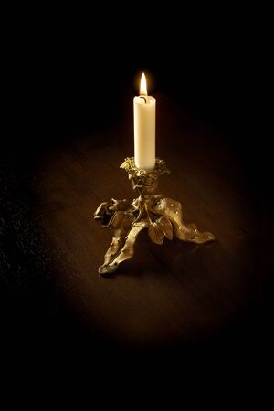 Golden candlestick with burning candleの写真素材
