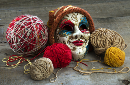 yarn and mask in a cap on a wooden tableの写真素材
