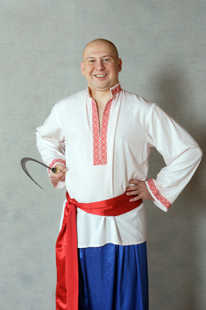 MOSCOW, RUSSIA - MARCH 4.2013:farmer with a sickle in the Russian national costume