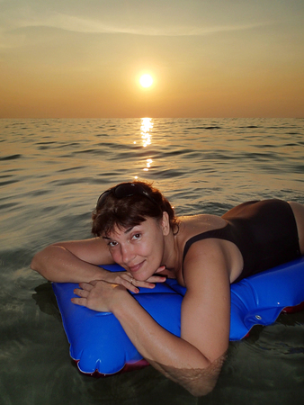 Girl on an air mattress in the seaの写真素材