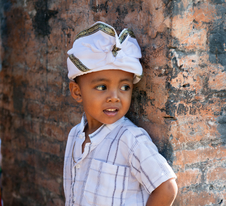 BALI, INDONESIA - AUGUST 22,2012:boy in holiday attire on a Balinese ceremonyのeditorial素材