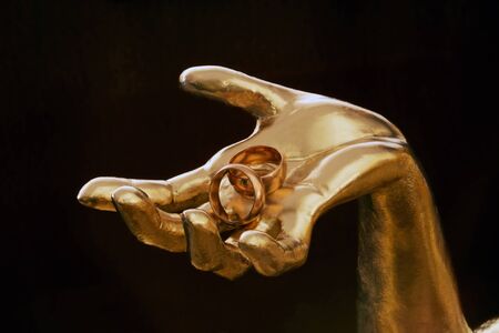 two wedding rings in gold handの写真素材