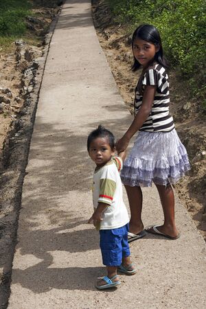 POPOTOTAN ISLAND, BUSUANGA, PHILIPPINES - JANUARY 20,2012 - Boy and girl moving on the road to the villageのeditorial素材