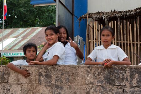 POPOTOTAN ISLAND, BUSUANGA, PHILIPPINES - JANUARY 21,2012: Girls and the boy  are laughing on a school break in the Philippine village.のeditorial素材