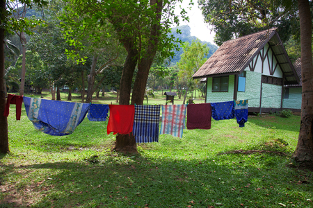 Laundered linens is dried in the garden near the houseの写真素材