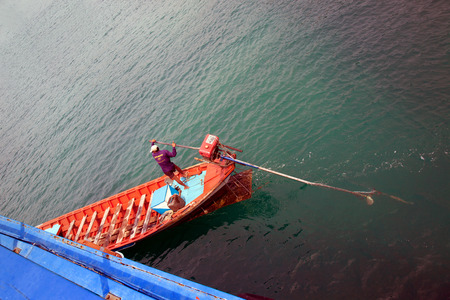 SAMUI,THAILAND- JANUARY 12, 2011: The Thai man turns the steering wheel of the large boatのeditorial素材