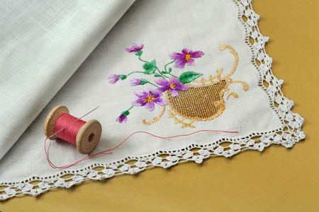 Thread with a needle and a handkerchief on a yellow backgroundの写真素材