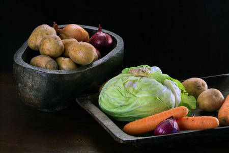 Potatoes, onions, carrots and cabbage in wooden bowlsの写真素材