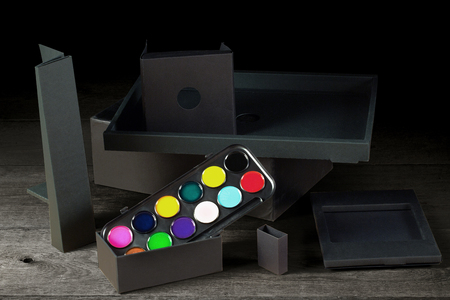 Watercolors and various black Ñonstructions on a wooden tableの写真素材
