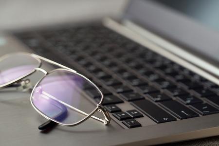 Glasses lying on the laptop keyboard