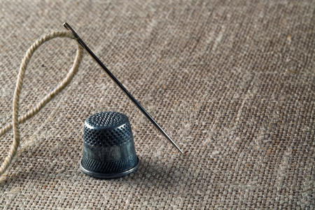 Thread with needle and thimble on canvas fabricの写真素材